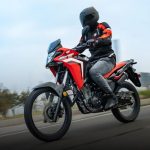 Honda Sahara 300: todo sobre la famosa trail mediana Una Honda XRE 300 sahara roja transita a buena velocidad por una ruta asfaltada