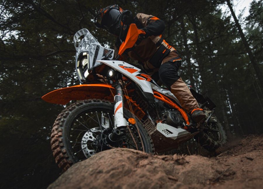 Un piloto tracciona una KTM 390 Adventure R sobre un macizo rocoso