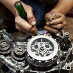 Un operario trabaja sobre un motor de moto fuera del vehículo