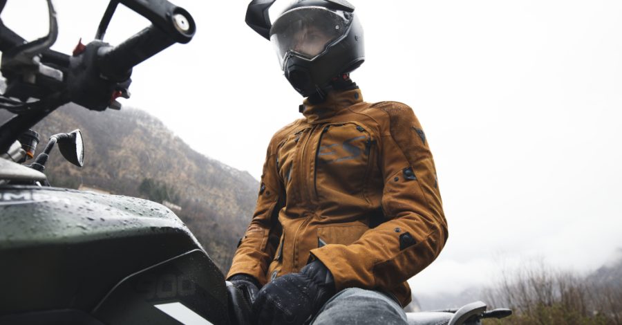 motociclista sobre su moto con chaqueta para lluvia