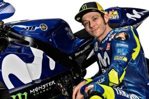 Valentino Rossi en cuclillas al lado de una moto Yamaha de MotoGP