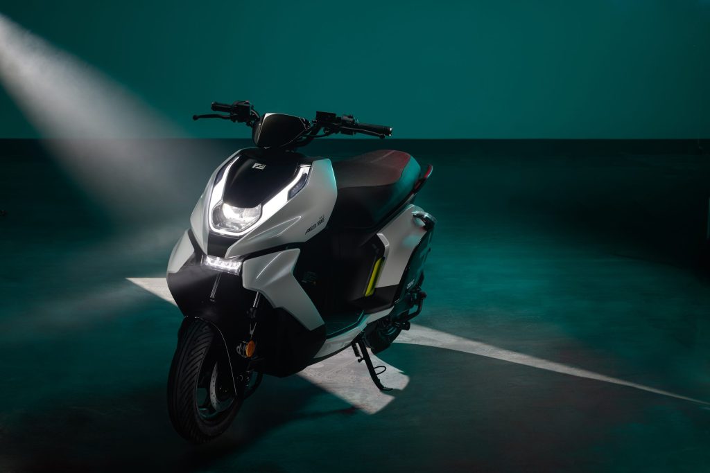 Un ZEEHO AE6+ posa para una foto comercial en un escenario azulado, con un haz de luz que ingresa desde arriba a la derecha
