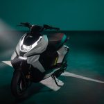 Un ZEEHO AE6+ posa para una foto comercial en un escenario azulado, con un haz de luz que ingresa desde arriba a la derecha