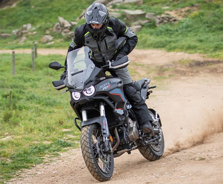 Un usuario se para sobre los pedalines de su Rieju Explora 707 para encarar un tramo terrestre 