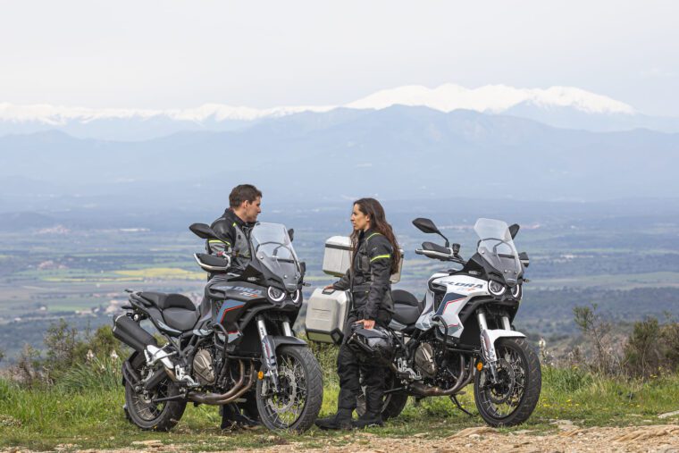 Una pareja de motociclistas de aventura conversan en medio de sus Rieju Explora 707