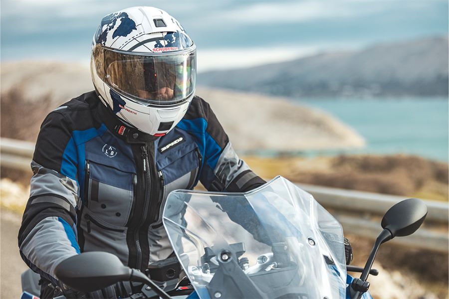 Un motociclista vanza en una moto Touring con un casco Schuberth C5 blanco