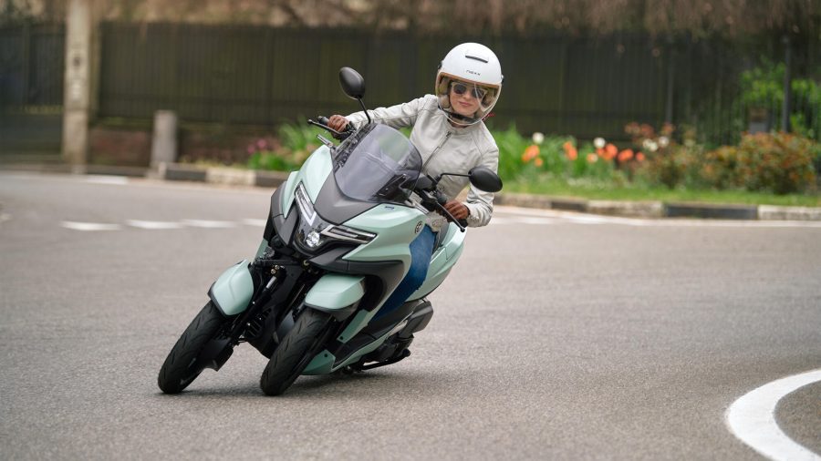 Una mujer gira a la izquierda con una Yamaha Tricity 125 verde
