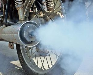 Un escape de moto echa humo azul