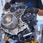 Un mecánico revisa un motor de moto fuera del vehículo