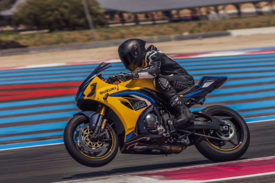 Una Suzuki GSX-R1000R 2026 amarilla lanzada a toda velocidad en un circuito con la rueda delantera en el aire