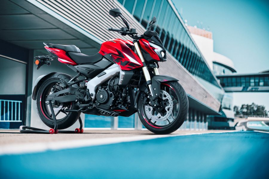 Una Bajaj Rouser NS 400 Z roja dispuesta para una foto comercial con fonde de autódromo