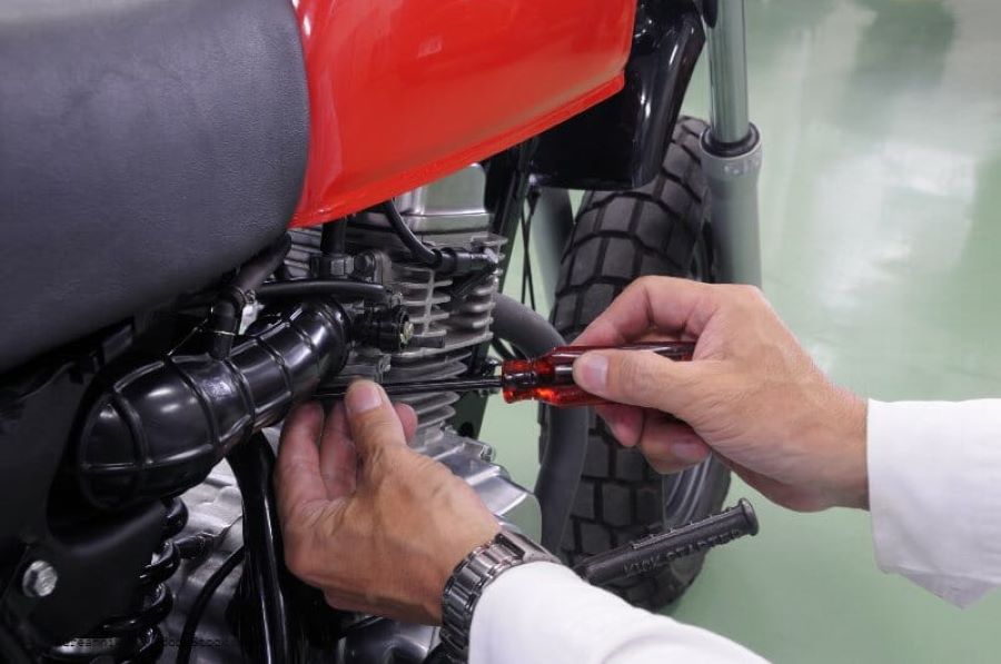 Un mecánico se dispone a desmontar un carburador de moto