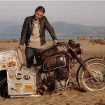 Kilómetros de coraje: la travesía de Elspeth Beard en moto Foto de Elspethh Beard apoyada en su moto, que tiene la rueda trasera enterrada hasta las maletas