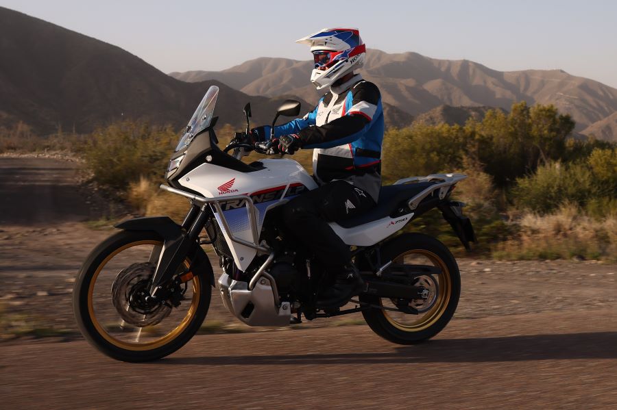 Una Honda XL750 Transalp blanca recorre el asfalto de una zona montañosa
