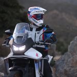 Nueva Honda Transalp 2025: de los Alpes a la Patagonia Un piloto gira su cabeza hacia la izquierda, sentado sobre su Honda XL750 Transalp 2025 blanca con las luces encendidas