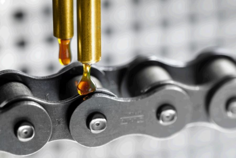 Dos gotas de aceite caen sobre una cadena de motocicleta