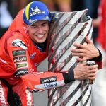 Marc Márquez, se agacha y abraza con los ojos cerrados el trofeo de su séptima corona en MotoGP