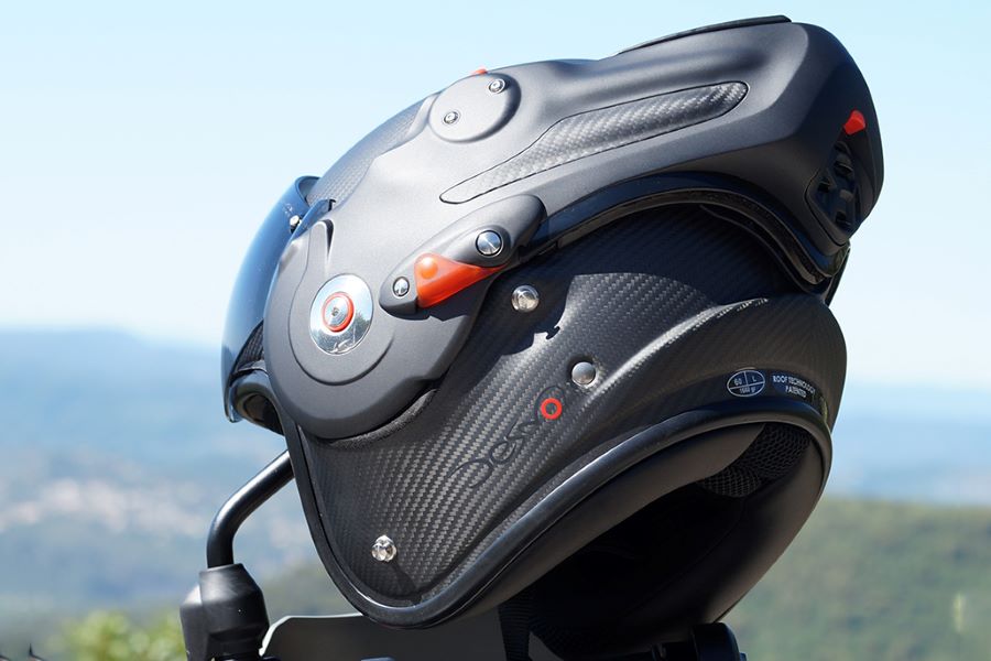 ROOF Desmo 3 Carbon, modular premium con estilo espacial Un casco modular Roof Desmo Carbon 3 descansa sobre el espejo de una moto