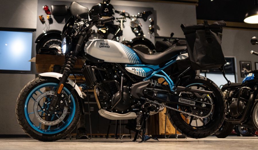 Una Royal Enfield GRR 450 blanca y azul dentro de un local comercial