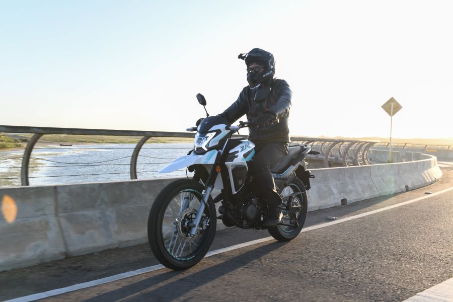 Una Zanella ZR 150 blanca se desplaza sobre un puente carretero