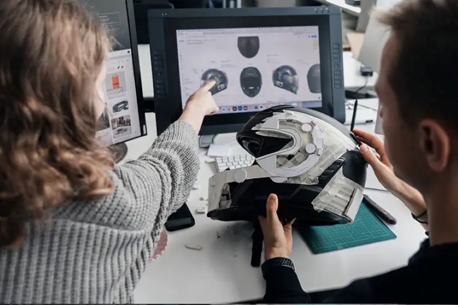 Ingenieros de Cardo Systems trabajan en el diseño del casco Beyond 2026 frene a la pantalla de computación