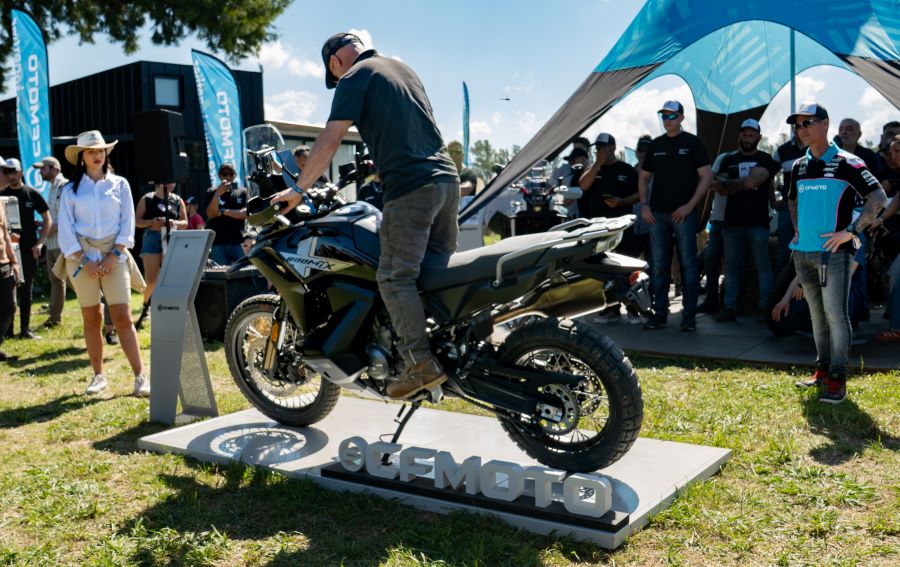 Un piloto de prueba se para sobre los pedalines de la CFMoto MT800-X durante un test raid