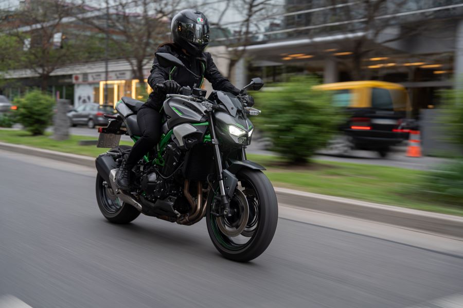 Una Kawasaki Z900 2025 verde se desplaza manejada por una mujer