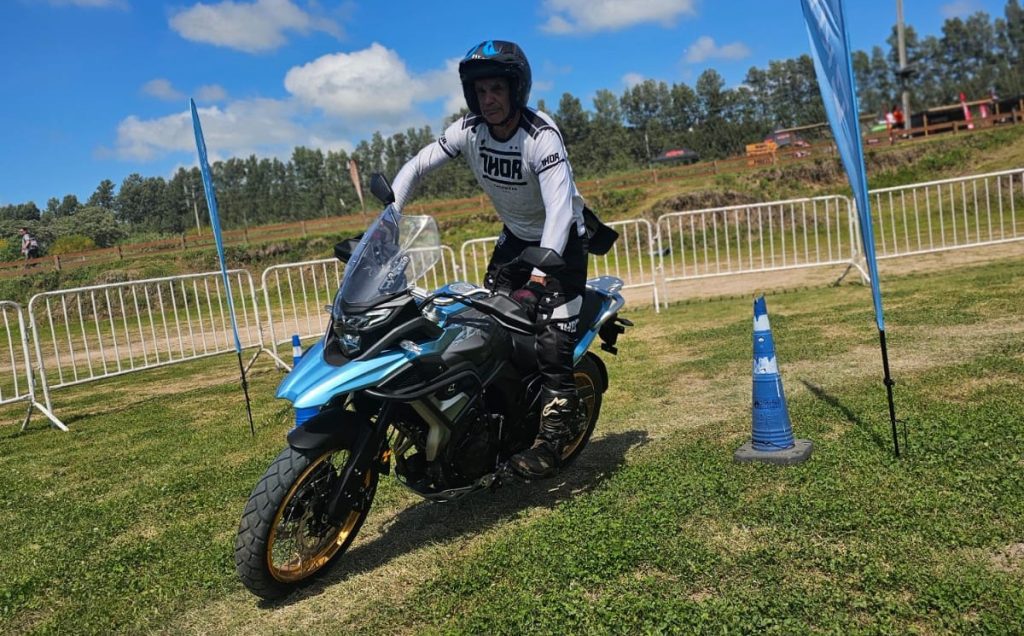Un piloto maniobra sobre una moto Kove Adventure azulen una pista de enduro