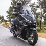 Vista lateral derecha de un scooter Kymco Xciting VS 400 circulando por una carretera