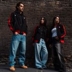 Indumentaria motera chic: seguridad y estilo urbano Tres modelos posan con ropa informal MacroXDucati con una pared rústica de fondo