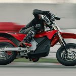 Un piloto dobla a la izquierda en un circuito y a toda velocidad sobre una VARG SM roja