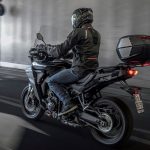 Una moto touring negra se moviliza con un baúl GIVI V49 AIR