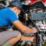 Una persona con barbijo lava una moto ¿Por qué una moto no arranca después de lavarla?