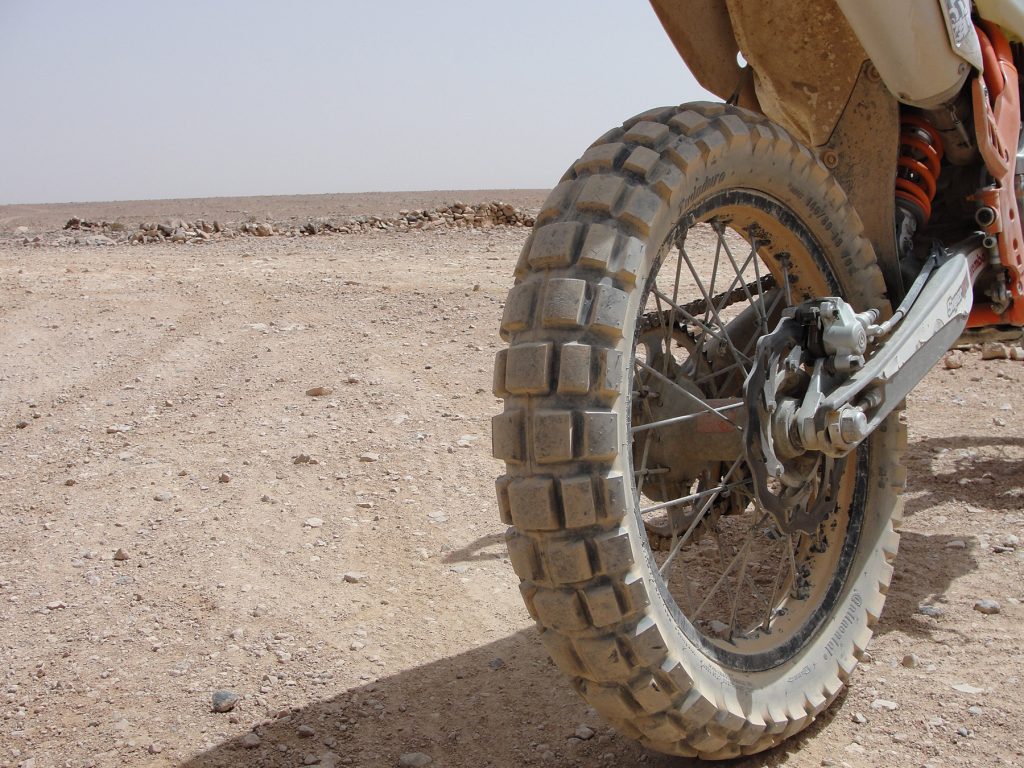 Vista trasera de una moto calzada con neumático de taco