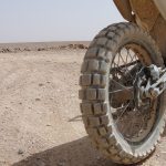 Neumático de tacos o mixto: cómo elegir según tu aventura Vista trasera de una moto calzada con neumático de taco
