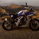 Vista lateral derecha de una BMW F 450 GS azul con un fondo de montañas