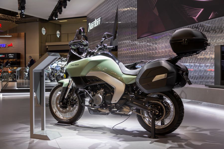 Vista lateral izquierda en perspectiva trasera de una moto Norton Atlas GT verde e su stand del Eicma 2025.