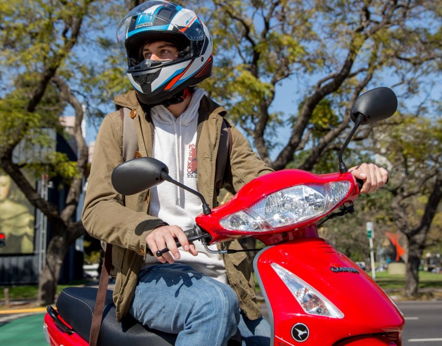 corven energy 110 2025 usuario con casco Un usuario con casco sentado sobre una moto Corven Energy 110 roja