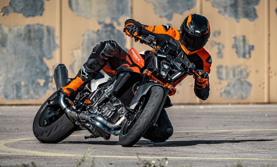 KTM 990 Duke 2026: estrategia firme para un modelo clave Una KTM 990 Duke 2026 naranja dobla acostada sobre su flanco izquierdo