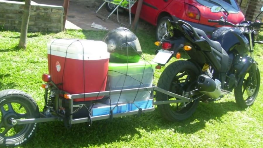 Una moto conectada a un remolque casero monorrueda