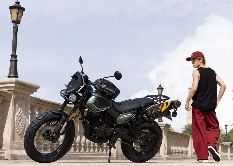 Mientras se aleja, un jovencito gira para observan su Letbe Flygon 125 ABS estacionada cerca de un baranda