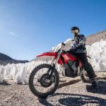 La Stark VARG EX demuestra el límite real de la combustión En primer plano una moto eléctrica Stark Varg EX roja a pleno sol pero rodeada de montículos de nieve