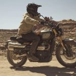 Triumph renueva la Scrambler 900 sin sacrificar su alma clásica Una moto Triumph Scrambler 900 2026 se desplaza por una ruta de tierra desértica