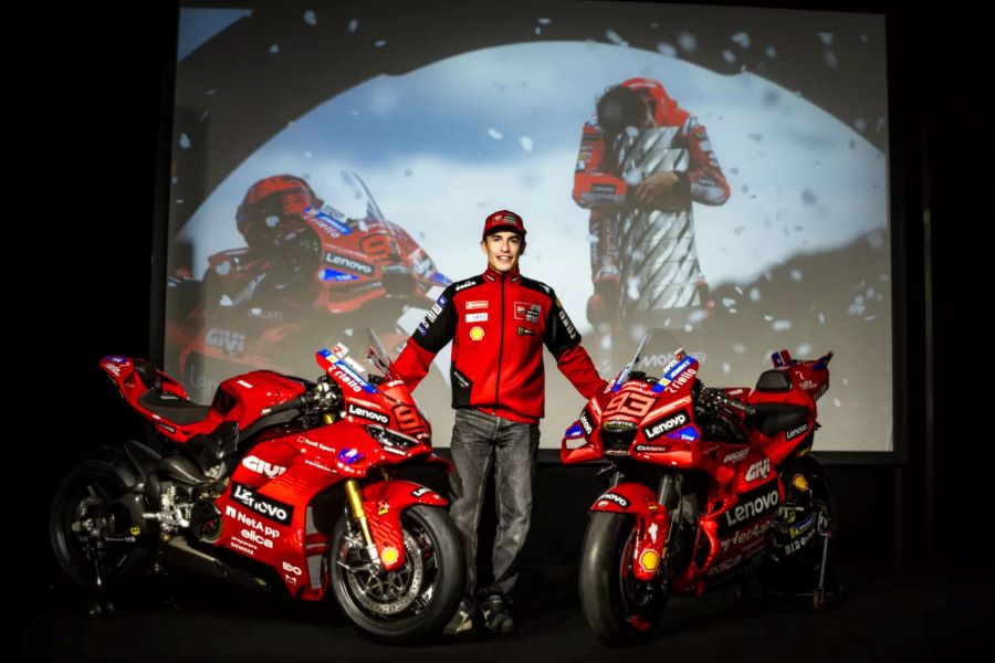 Marc Márquez sostiene dos modelos de la Ducati Panigale V4 Márquez 2025 World Champion Replica