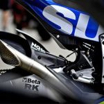 Una moto Suzuki conta un contorneado escape deportivo Akrapovic