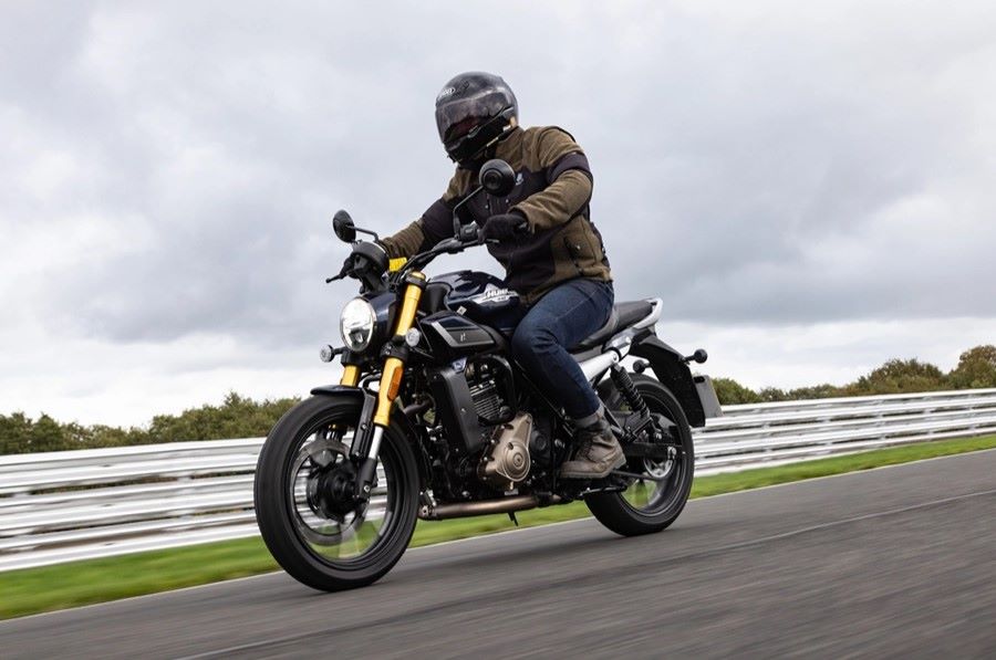 Un motociclista se desplaza por una ruta en una moto Hero Hunk 440 negra