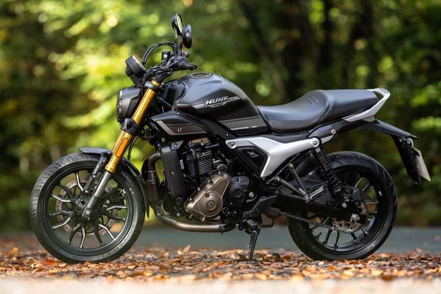 Hero Hunk 440: una roadster pensada para mercados reales Vista lateral izquierda de una moto Hero Hunk 440 nagra con fondo de bosque