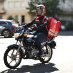 Una Bajaj Boxer CT100 utilizada para trabajo de reparto de comida
