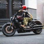 Una mujer maniobras su Benda Dark Flag 950 rojo borravino en una ciudad