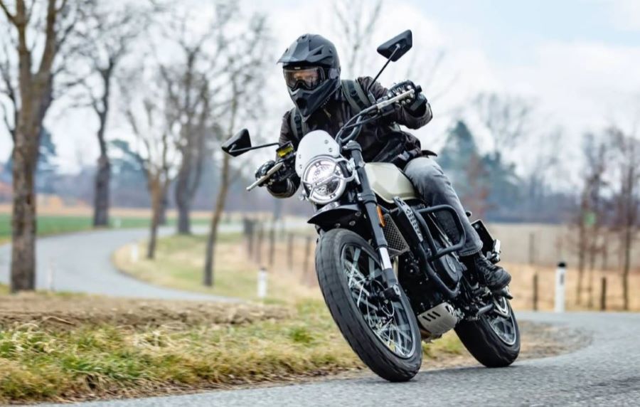 Con la Crossfire 500 XC, Brixton encuentra su punto de madurez Un pìloto avanza montado en una moto Brixton Crossfire 500 XC por una carretera otoñal